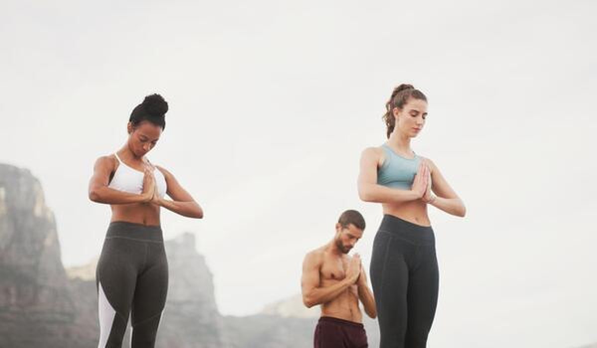 Two people stretching outdoors as part of an everyday wellbeing routine