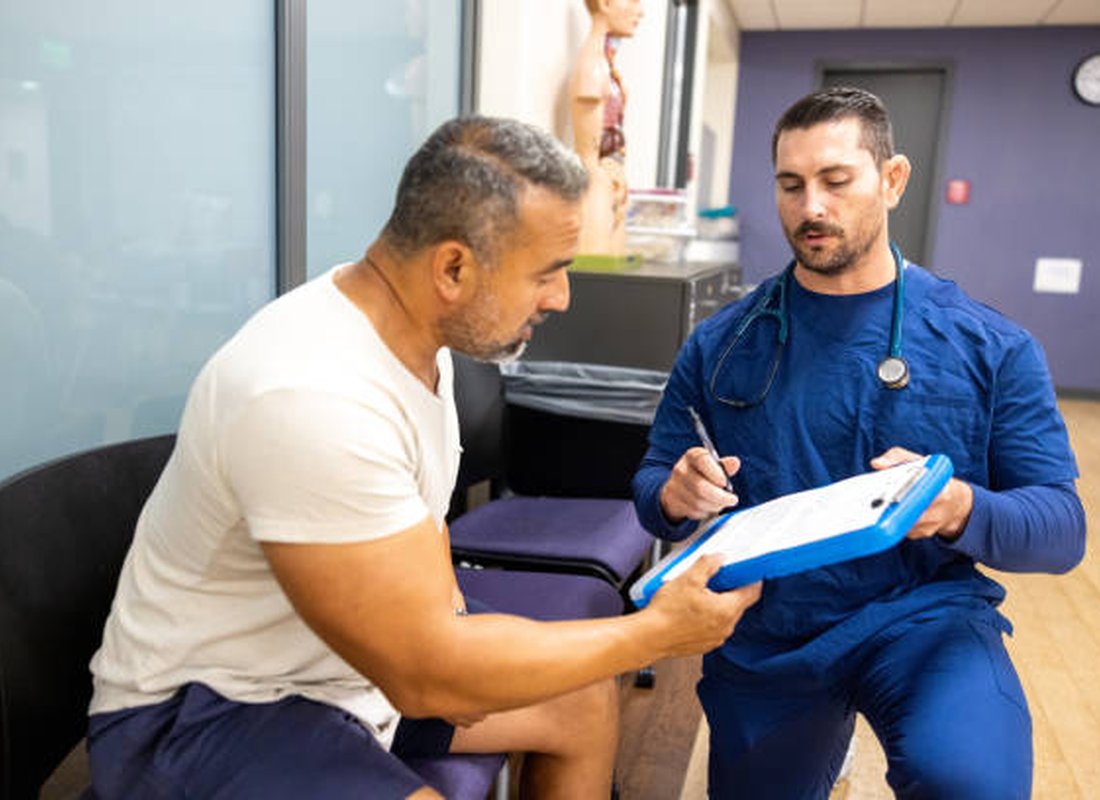 A clinician reviewing paperwork with a patient at a desk
