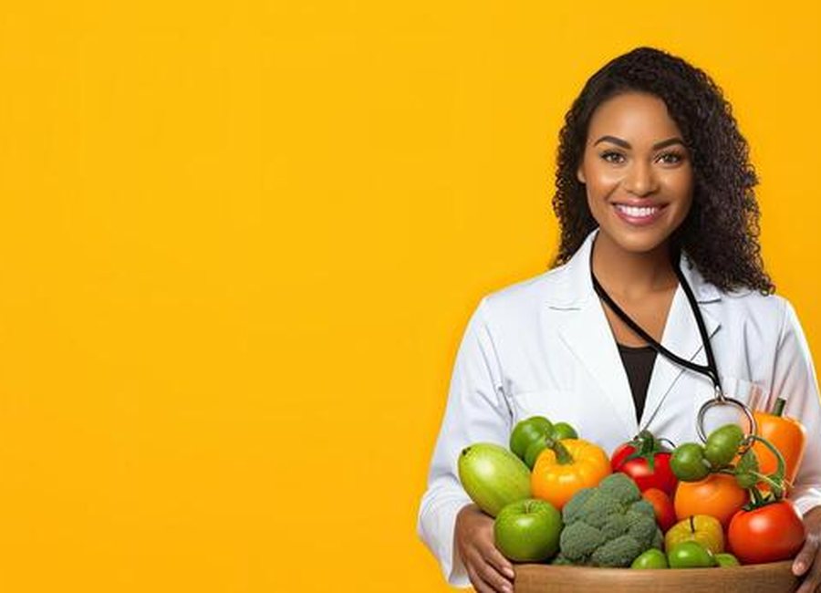 A nutrition professional holding a bowl of fresh vegetables and fruit