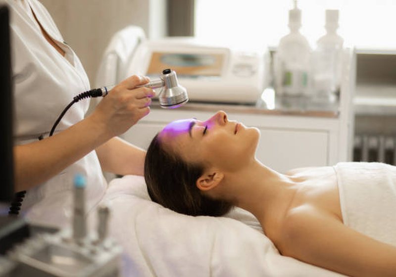 A skin care specialist performing a facial treatment in a calm clinic room