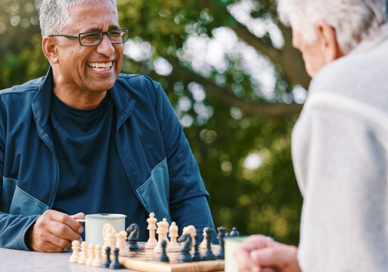 An older adult enjoying a game of chess, supporting memory and cognitive health